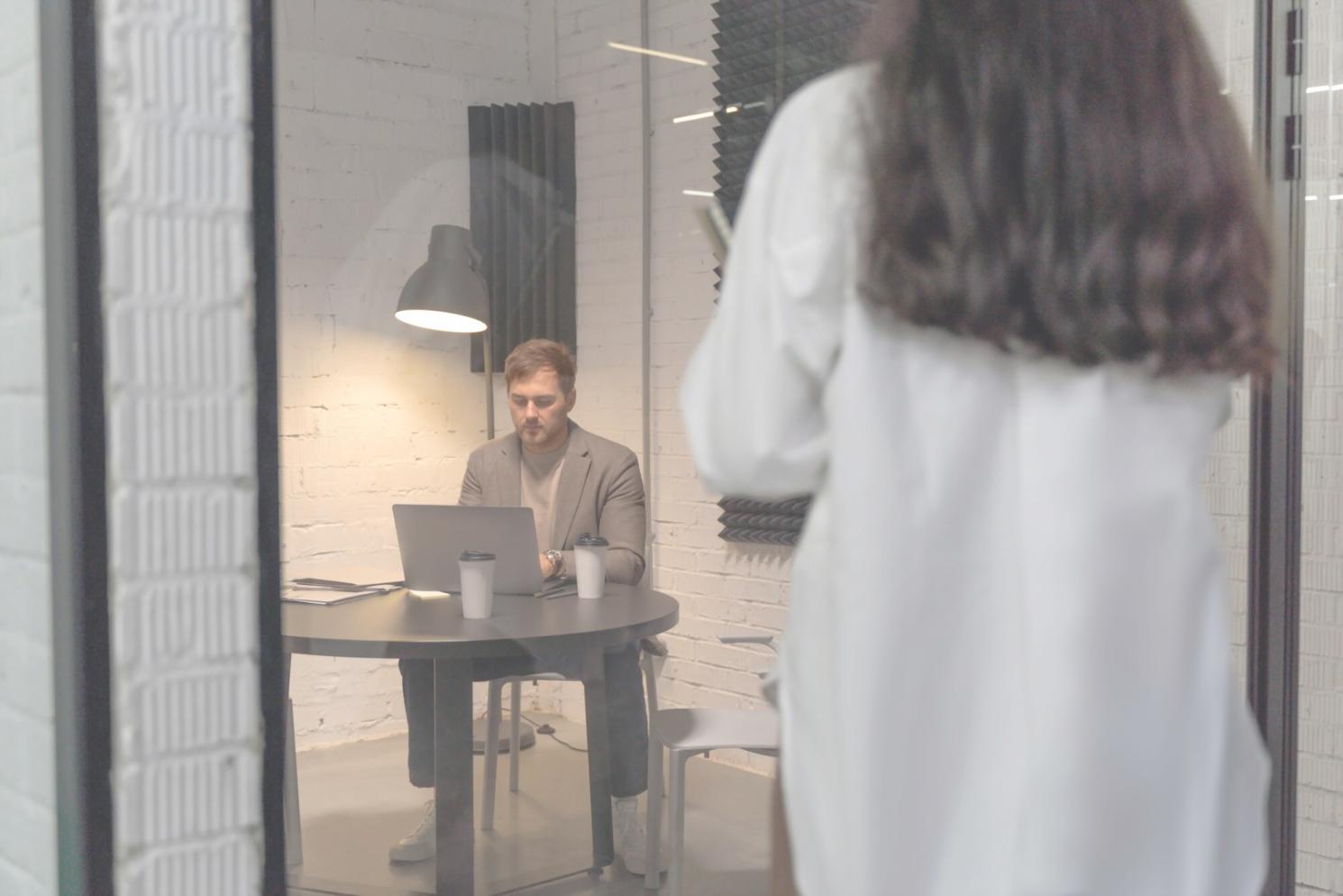 Personne travaillant avec concentration sur son ordinateur dans un espace de travail organisé